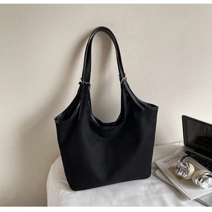 Detail view of the black matte tote bag showing the texture and adjustable leather strap