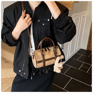 Detalle del bolso Boston en cuero granulado caqui con un lindo colgante de oso