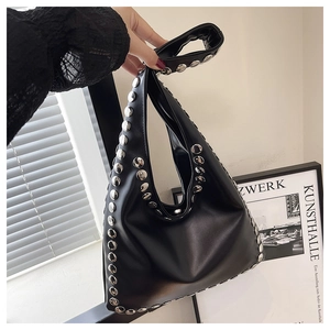 Gros plan sur un sac cabas noir en similicuir avec des rivets cylindriques argentés denses