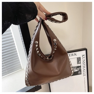 Détail du sac à main en cuir marron avec rivets métalliques argentés et texture vintage