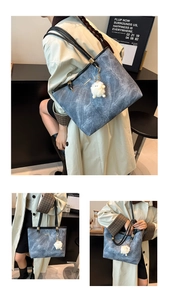 Detail view of large capacity blue marble texture tote bag with white plush ball charm accessory