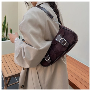 Détail du sac croissant en daim marron avec boucle vintage et bandoulière chaîne
