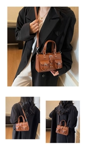 Detail view of brown lychee grain leather handbag with silver buckles and rivets