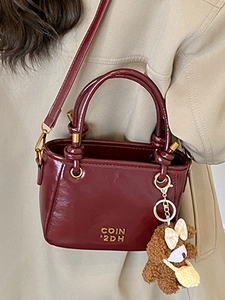 Sac seau chic en cuir verni bordeaux avec poignées et breloque ours en peluche