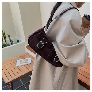Détail du sac à bandoulière vintage en daim marron foncé avec boucle en métal et fini mat