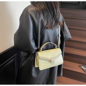 Detail of pistachio green leather crossbody bag with V-flap and square buckle closure