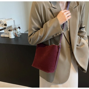Detail of burgundy suede tote bag with Harson Bags embossed logo on minimalist surface