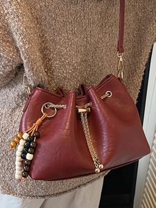 Vintage burgundy bucket bag with gold chain drawstring and bohemian tassel charm