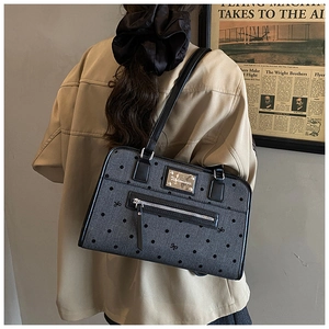 Close-up of gray canvas tote bag with black polka dots and butterfly embroidery details