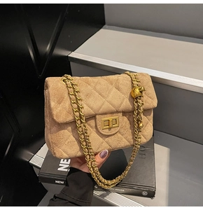 Dettaglio borsa trapuntata in camoscio beige con chiusura dorata e tracolla a catena