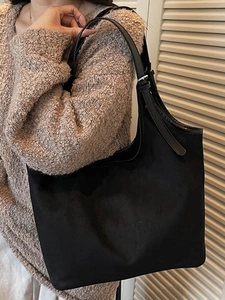 Classic large black tote bag with adjustable leather straps for stylish autumn commuting