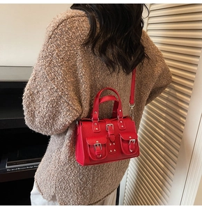 Detail of red pebbled leather mini crossbody bag with silver hardware on model