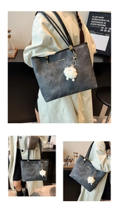Detail of grey washed texture tote bag with black straps and plush lamb pendant