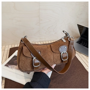 Détail du sac bandoulière vintage en daim marron avec doubles boucles et fermeture éclair