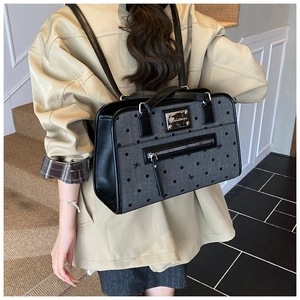 Detail of the gray polka dot backpack with black leather straps and silver zipper pocket