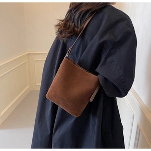 Brown frosted suede tote bag detail with shoulder strap and embossed fashion logo