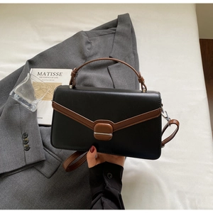 Detail view of the black and brown contrast leather handbag with elegant square metal lock
