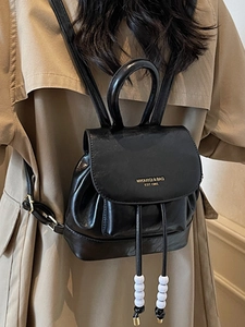 Vintage black leather mini backpack with drawstring closure and golden logo print