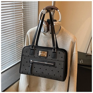 Close-up of dark grey tote with bow pattern, gold hardware and decorative tassel