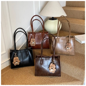 Detailed row of vintage tote bags in four colors with cute plush bear charms on stairs