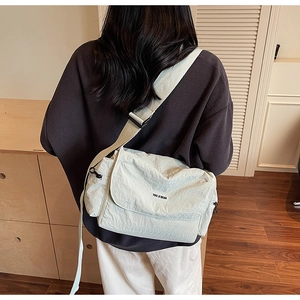 Detail showing the adjustable wide shoulder strap and black zipper of the cream tote bag