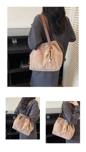 Detail of drawstring canvas tote bag with wooden bead charm and faux leather straps