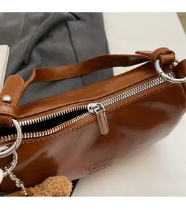 Close-up of silver metal zipper and brown leather texture on cylindrical bag