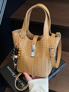 Sac seau tissé marron en cuir avec fermoir argenté et pompon décoratif en perles