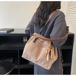 Detail view of large drawstring tote bag with matte texture and brown leather strap
