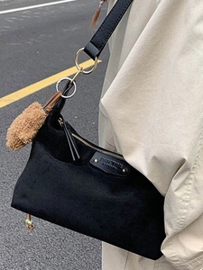 Minimalist black tote bag with gold zipper and brown fluffy pompom for autumn daily wear