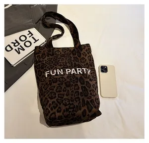 Leopard print tote bag size comparison with smartphone and branded book prop