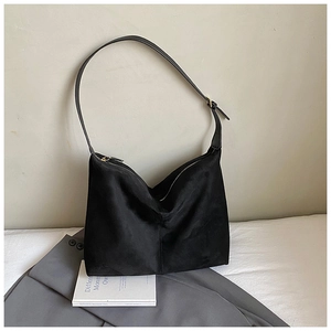 Detailed macro shot of a black hobo bag in soft matte suede with metal zipper and buckle
