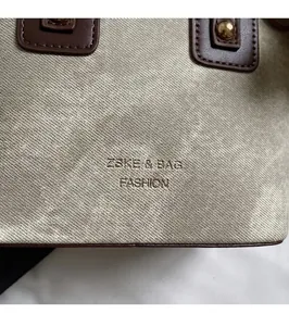 Detailed close-up of champagne canvas texture with brown leather trim and gold rivets
