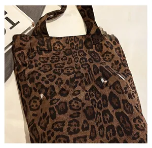 Detailed view of plush leopard print tote bag with Fun Party text on white fabric