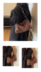 Detail of brown hobo bag with monogram pattern and decorative wooden bead shoulder strap