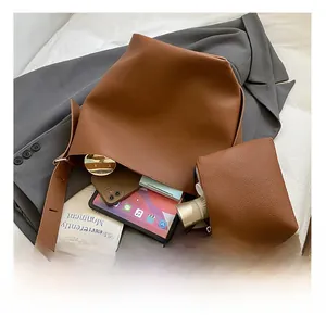 Detail view of brown pebbled leather bucket bag interior holding a tablet and cosmetics