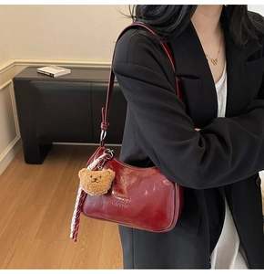 Deep red patent leather underarm bag with a cute bear charm and checkered scarf detail