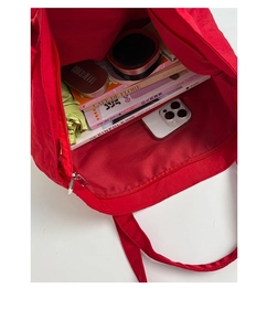 Macro detail of red tote bag interior with large storage capacity and zipper closure