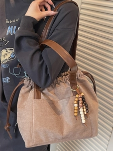 Minimalist large brown suede tote bag with drawstring closure and stylish wooden bead charm