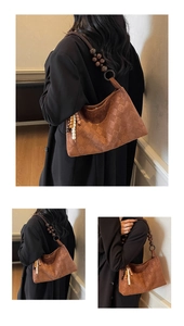 Detail of caramel quilted shoulder bag featuring unique large wooden bead strap accents