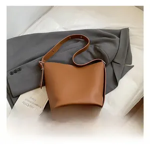 Detailed view of the brown lychee pattern leather bucket bag on white sheets