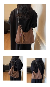 Detail of vintage brown suede hobo bag with woven tassel charm shown on model shoulder