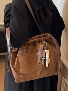 Brown suede drawstring tote bag with bohemian beaded charms for minimalist daily commute