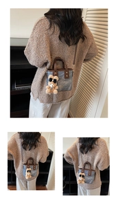 Detail van blauwe denim bucket bag met leren bies en schattige teddybeer hanger