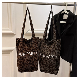 Detailed view of plush leopard print tote bags in brown and grey with Fun Party text