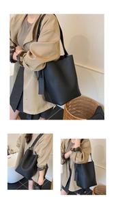 Detail of black lychee grain leather bucket bag featuring spacious storage and side charms