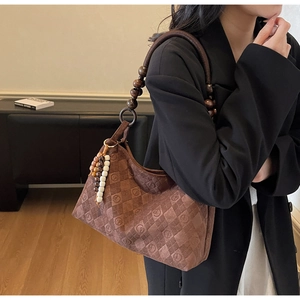 Detailed macro view of dark coffee suede tote with wooden beads and diamond lattice pattern