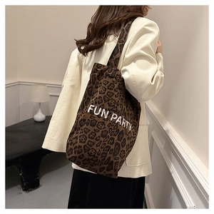 Detail of spacious leopard print tote bag with 'FUN PARTY' text and plush texture
