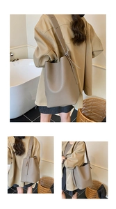 Detail view of large taupe bucket bag with pebbled leather texture and wide strap