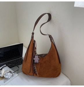 Brown vintage suede hobo bag with fringe details and leopard bear charm in a lifestyle set